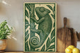 a wooden cutting board with a decorative green and white design depicting a chameleon climbing a tree.