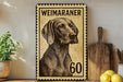 A Weimaraner dog stamp with the number 60 on it, placed on a shelf next to a wooden cutting board and some lemons.