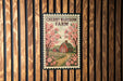 A sign for Cherry Blossom Farm, featuring a red barn and pink cherry blossoms against a wooden background.