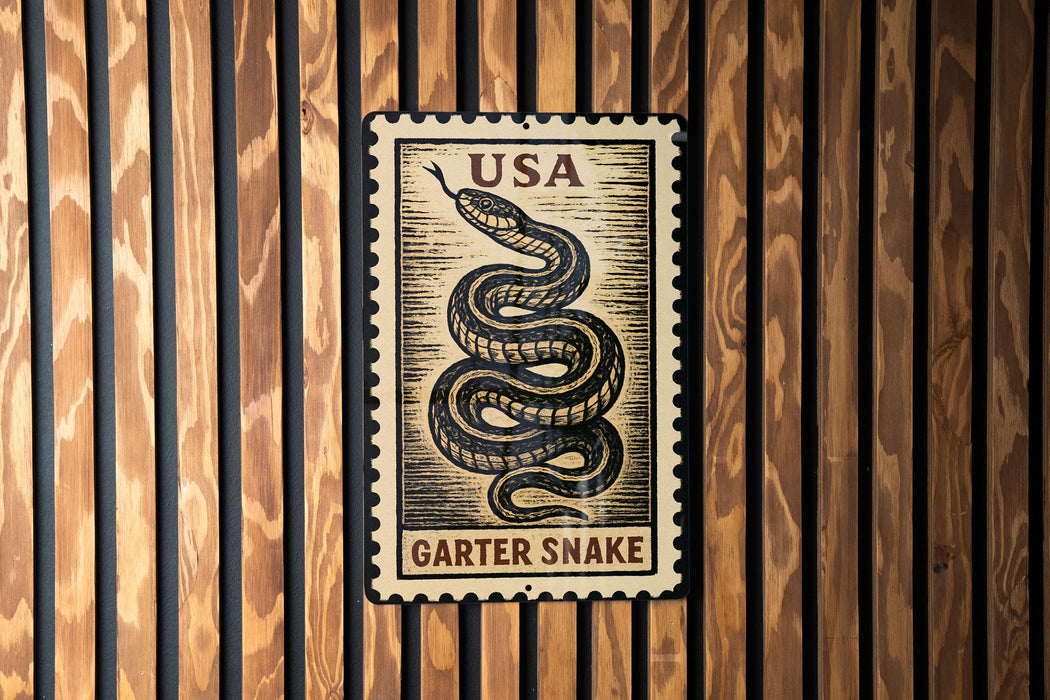 A metal sign with a black and white illustration of a garter snake on a wooden background.