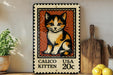A metal sign featuring a calico kitten on a wooden frame, with a stamp-like border and text indicating it is a calico kitten.
