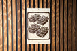A sign with a black and white illustration of four identical plant pots with plants growing in them, mounted on a wooden wall.