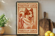 a framed poster of a dog, with the text "YAKUTIAN LAIKA" printed on it. The poster is displayed on a shelf next to a wooden cutting board and some kitchen utensils, such as a knife and a spoon.