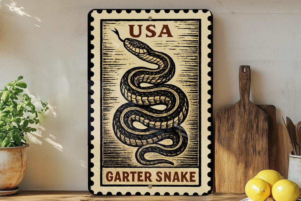 A framed image of a garter snake on a wall, with a wooden cutting board and a potted plant to the left.