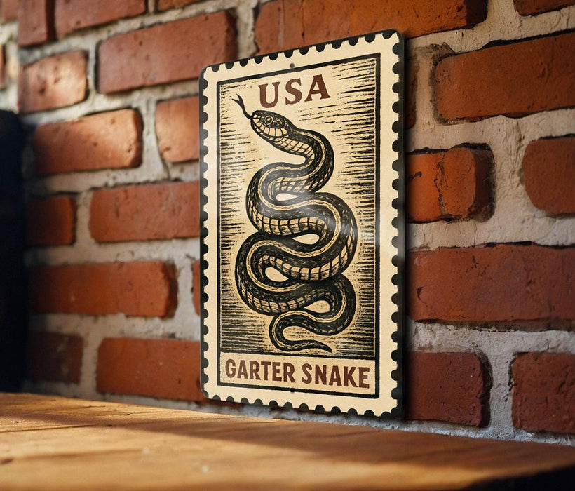 A framed image of a garter snake, which appears to be a U.S. postage stamp, is mounted on a brick wall.