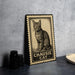 A metal sign featuring a cat illustration and the text "CHAUSIE CAT" is displayed on a table.