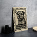 A 5c postage stamp featuring a dog's portrait, placed on a table next to some black camera lenses.