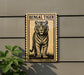 a tiger standing on a grassy area, with a stamp-like border around it.