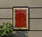 a red wooden door with a black border, mounted on a gray wall.