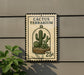 A sign for the Cactus Terrarium, featuring a cactus plant inside a glass dome, mounted on a wall.