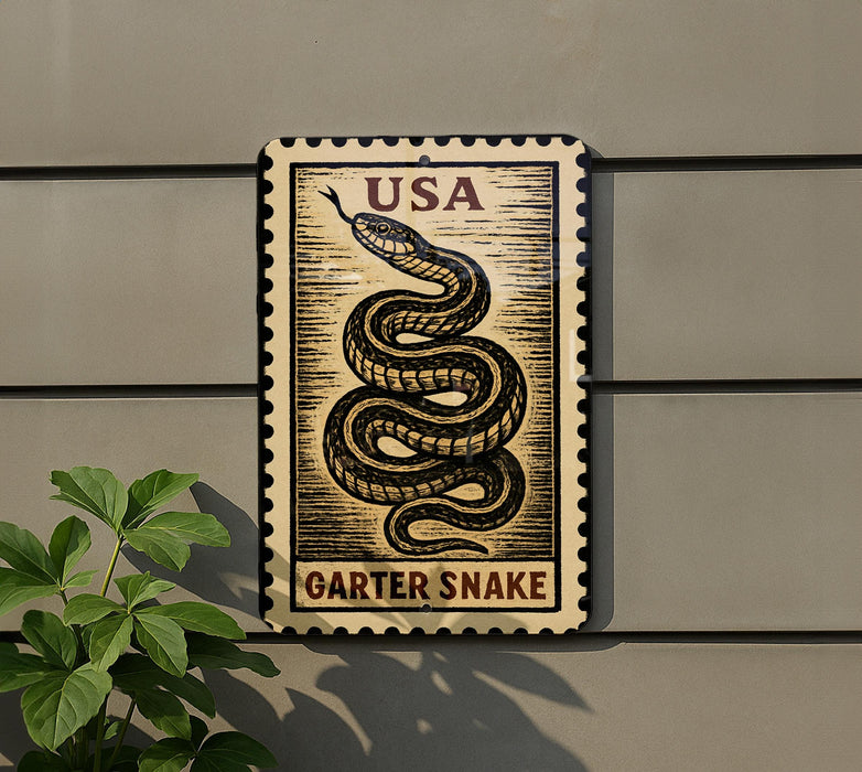 A metal sign with a snake design and the text "USA GARTER Snake" is mounted on a wall, with a plant visible to the left.