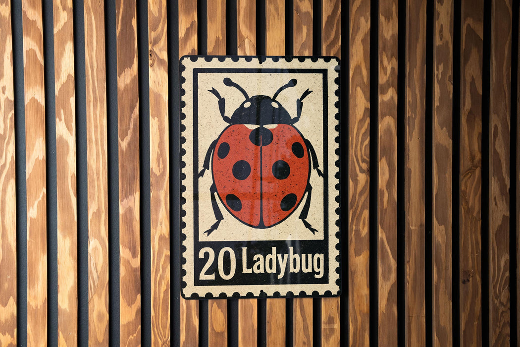 A metal sign featuring a ladybug illustration is mounted on a wooden wall.