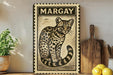 a framed illustration of a leopard cat, with a wooden cutting board and a potted plant in the background.