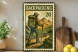 A vintage-style metal sign with a backpacker illustration, featuring a mountain landscape and the text "BACKPACKING 20".