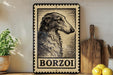 A framed image of a Borzoi dog, a breed of Russian Greyhound, is displayed on a shelf next to a wooden cutting board and some kitchen utensils.