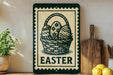 a sign with the word "EASTER" on it, along with a basket of Easter eggs. The sign is placed on a shelf next to a wooden cutting board and a potted plant.