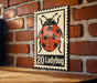 A metal sign featuring a ladybug illustration is mounted on a brick wall.
