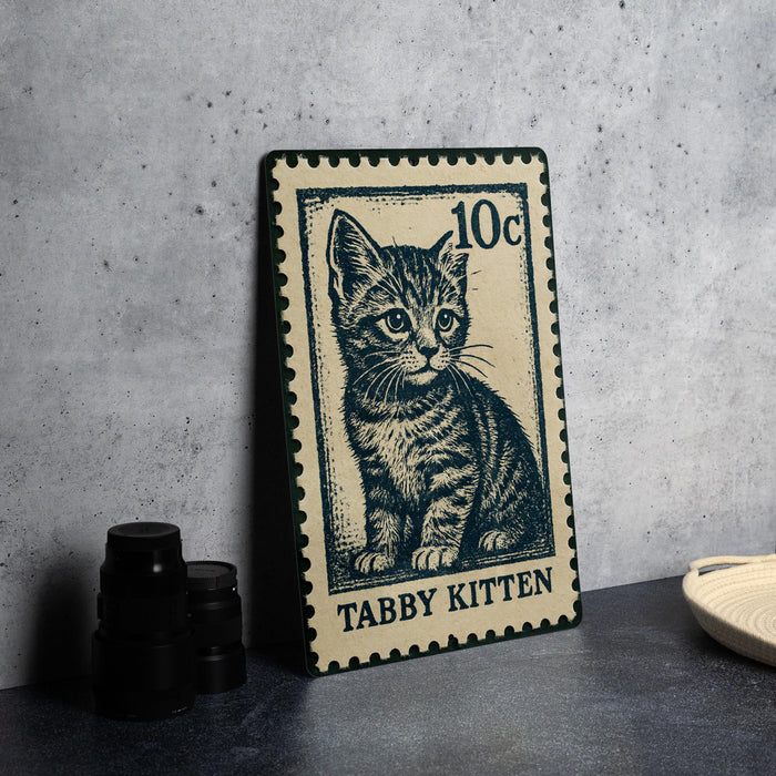 A metal stamp featuring a cat illustration, with the text "Tubby Kitten" printed on it.
