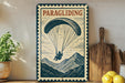 A vintage-style metal sign with the word "PARAGLIDING" printed on it, featuring an illustration of a person paragliding over a mountain landscape.