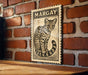 A framed illustration of a leopard is displayed on a brick wall, with the word "MARGAY" written above it.
