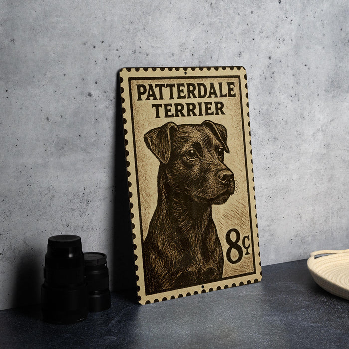 A metal sign featuring a black and brown illustration of a Patterdale Terrier dog, with the text "PATTERDALE TERRIER" printed on it.