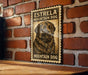 A vintage-style metal sign with a dog illustration and the text "ESTRELLA MOUNTAIN DOG" is displayed on a brick wall.