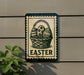 a sign with a basket of Easter eggs on it, mounted on a wall.