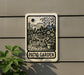 A sign for a patio garden, featuring a black and white illustration of a patio area with a table and chairs, surrounded by potted plants.