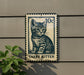 A metal sign featuring a cat illustration and the text "Tubby Kitten" is mounted on a wall.