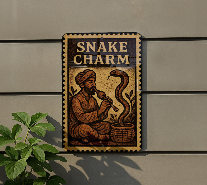 a sign with the word "SNAKE CHARM" and an illustration of a man playing a flute while a snake is in a basket.