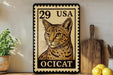 A framed image of a cat, specifically aOCICAT, is displayed on a shelf next to a wooden cutting board and some potted plants.