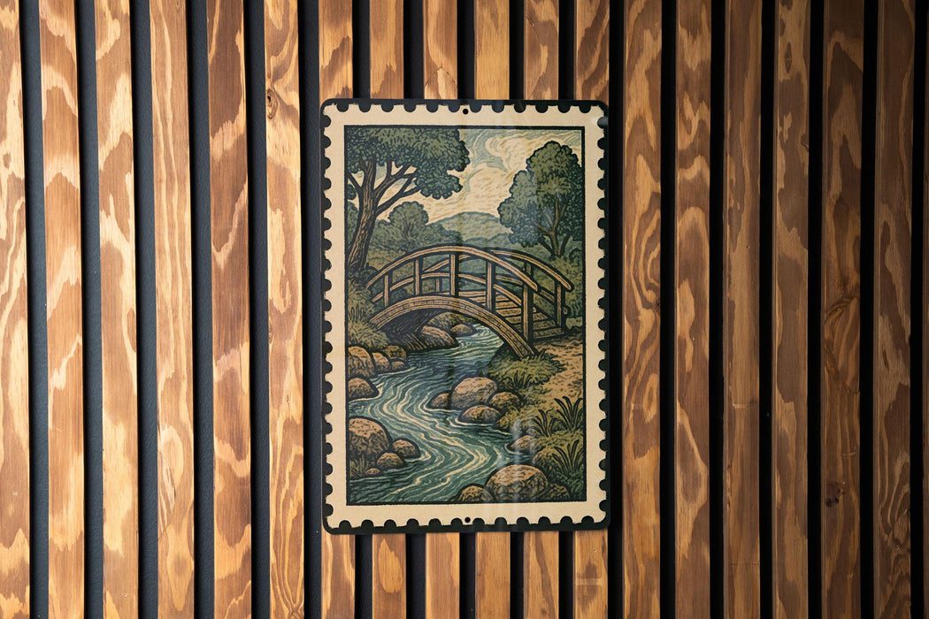 A framed illustration of a wooden bridge spanning a river is displayed on a wooden wall.