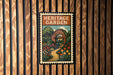 A vintage-style metal sign with a garden scene and a path, mounted on a wooden wall.