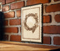 a decorative wreath with grapes hanging from it, mounted on a brick wall.