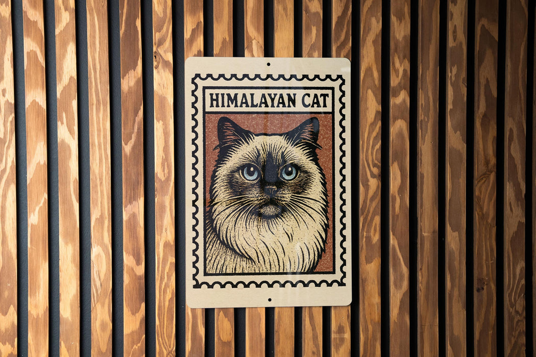 A framed image of a Himalayan cat is displayed on a wooden wall.