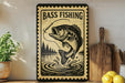 A vintage-style metal sign with a fish illustration and the text "BASS FISHING" is displayed on a shelf, accompanied by a wooden cutting board and a potted plant.