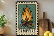 A framed illustration of a campfire is displayed on a shelf, accompanied by a wooden cutting board and a potted plant.