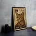 A framed image of a cat, specifically an ocicat, is displayed on a table.