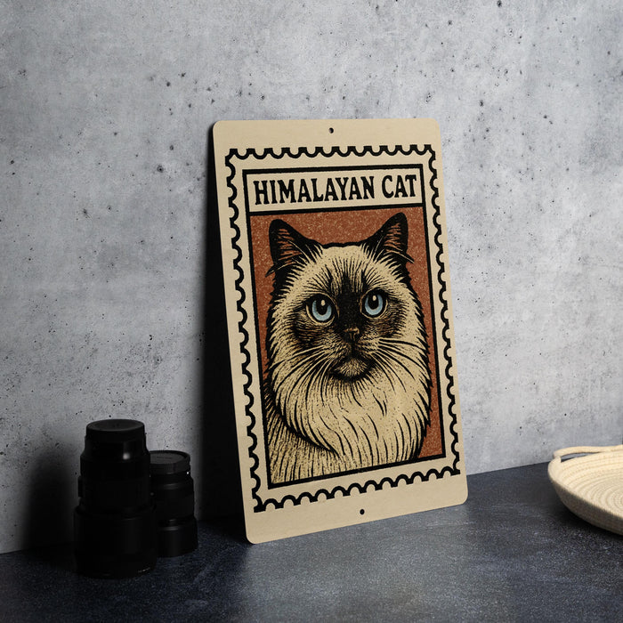 A framed illustration of a Himalayan cat is displayed on a wall, with a stack of black camera lenses to the left and a white dish to the right.