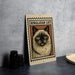 A framed illustration of a Himalayan cat is displayed on a wall, with a stack of black camera lenses to the left and a white dish to the right.