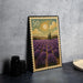 A framed postage stamp depicting a lavender field with a sun and clouds in the background.