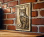 A wooden table with a brick wall in the background, featuring a framed image of a cat on the wall.