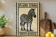 A framed illustration of a zebra is displayed on a shelf, accompanied by a wooden cutting board and a potted plant.