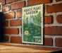 a vintage-style metal sign with a lush green plant illustration, mounted on a brick wall.