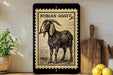 a framed illustration of a goat, which appears to be a Nubian goat, on a shelf next to a wooden cutting board and some lemons.