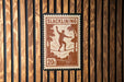A postage stamp featuring a man walking on a tightrope, with the word "SLACKLINING" printed on it.