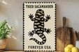 A framed poster of a tiger salamander is displayed on a shelf, with a wooden cutting board and lemons nearby.