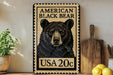 A framed image of a black bear on a wall, with a stamp-like border and text indicating it is an American black bear.