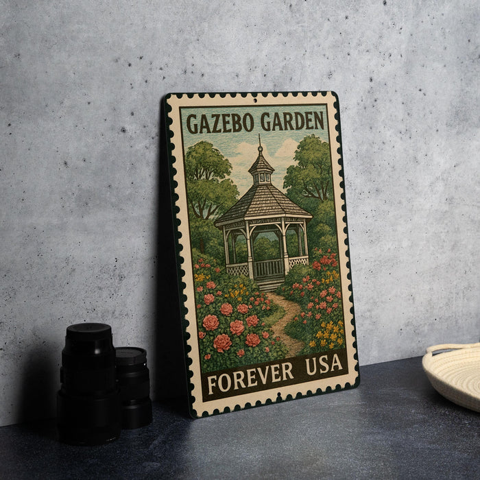 A metal sign with a gazebo and flowers, labeled "Gazebo Garden Forever USA", is displayed on a table next to some black camera lenses.