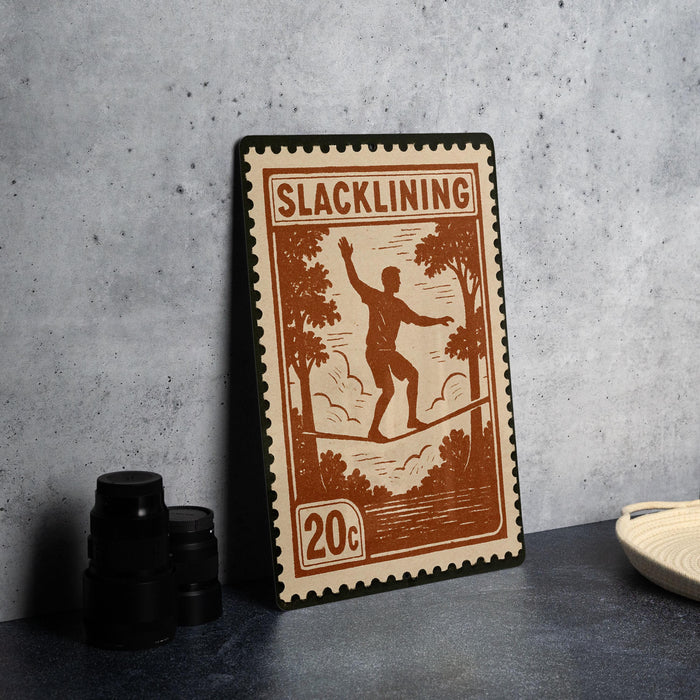 A wooden stamp with the word "SLACKLINING" printed on it, featuring a silhouette of a person balancing on a tightrope.